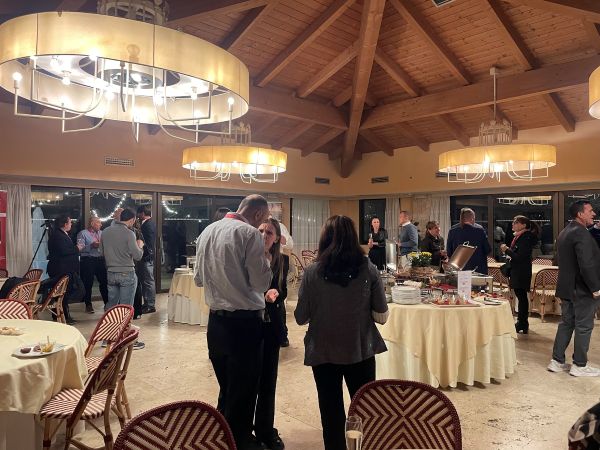 Album cover with people conversing in an event venue